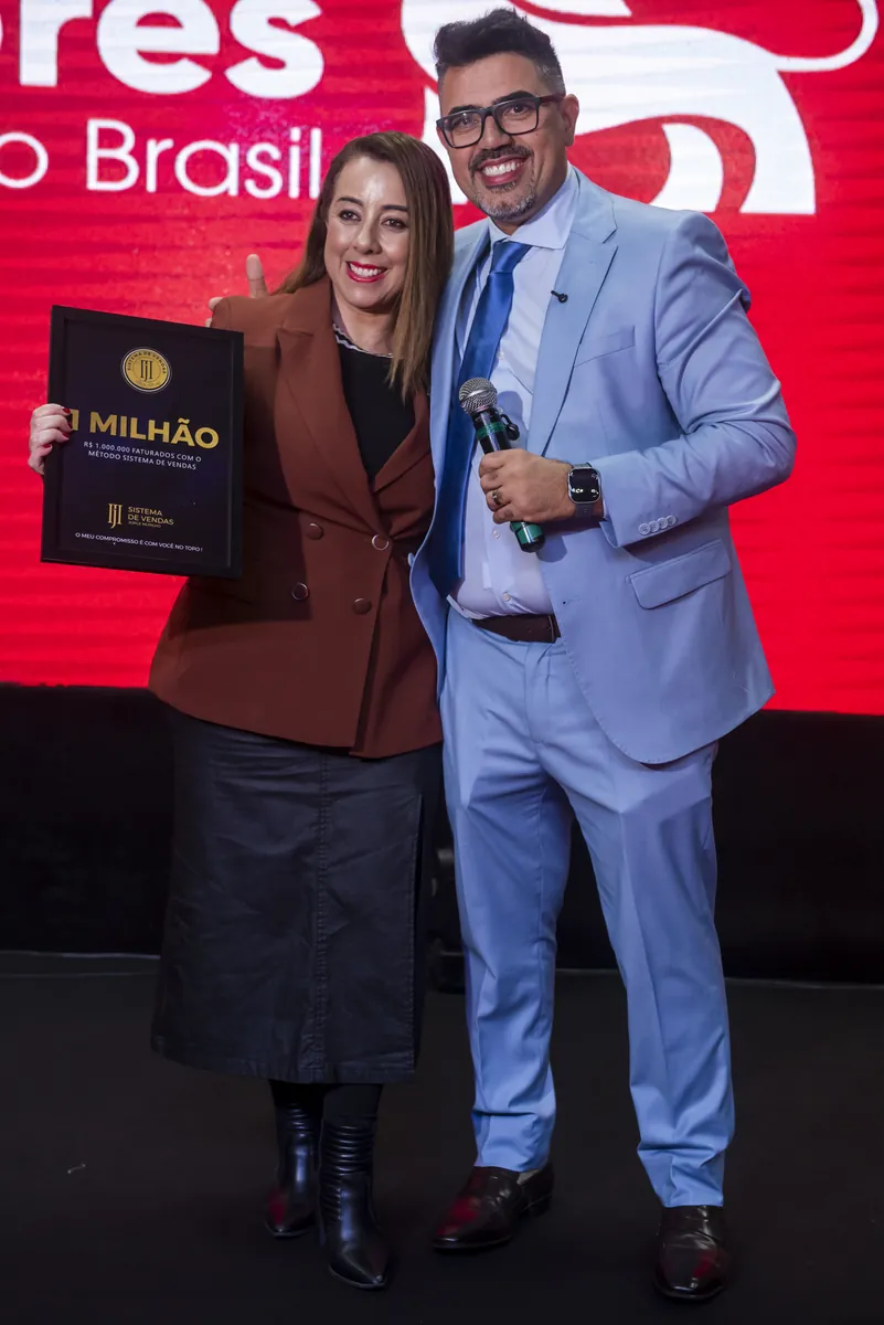 Mentorada recebendo a placa 1 Milhão no palco do evento