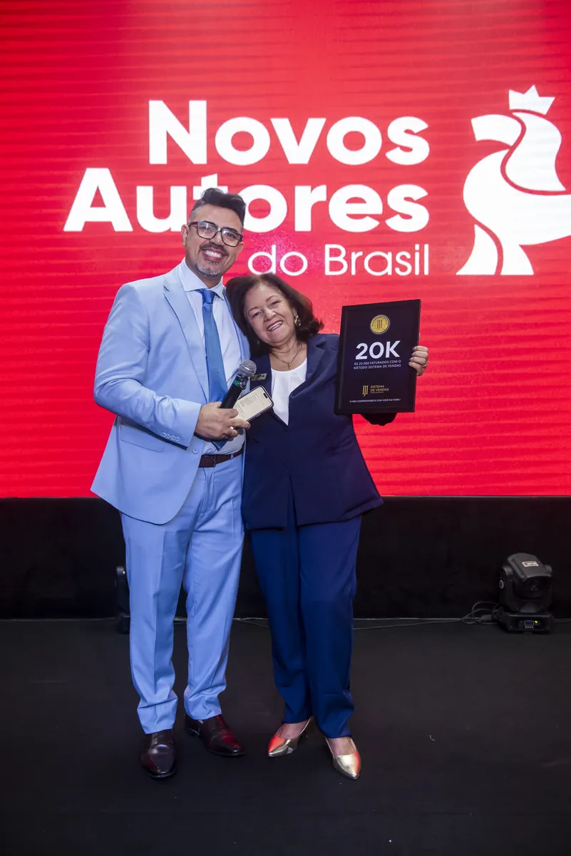 Mentorada recebendo a placa 20K no palco do evento